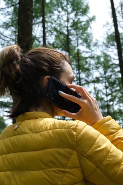 Ormanda cep telefonu kullanan bir kadın