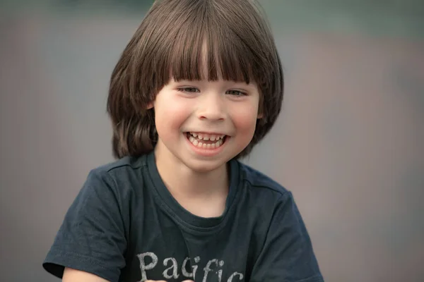 Glimlachend Kindergezicht Portret Wazige Achtergrond Weg Kijkend Van Camera — Stockfoto
