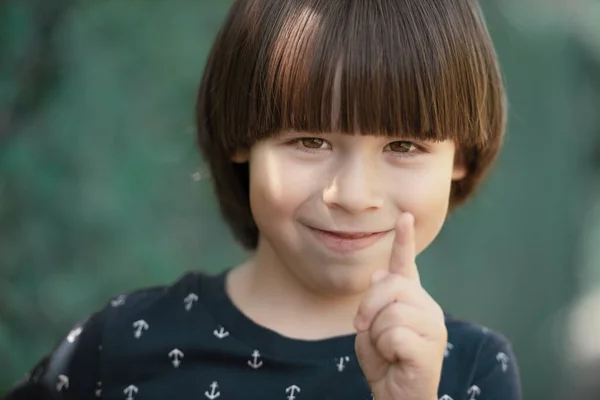 Kind Lacht Kwispelt Een Vinger Gezicht Portret Wazige Achtergrond — Stockfoto