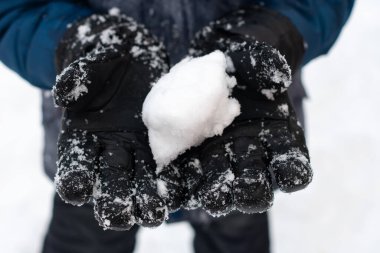 Siyah eldivenler bir kartopu tutar