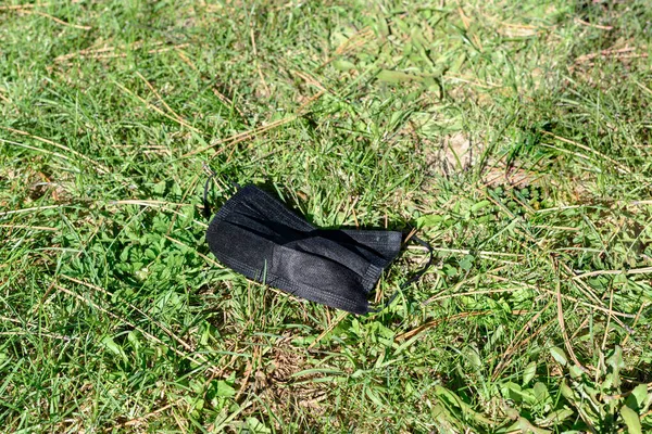 Black Surgical Face Mask Lying Ground Grass Concept End Its — Stock Photo, Image