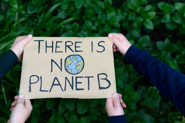海报被两个孩子牵着 上面写着 没有行星B 环境保护的概念 免版税图库照片