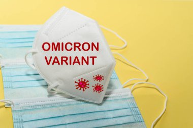 Ameliyat maskesinin üzerinde Omicron Variant yazan beyaz yüz maskesi. Koronavirüsün Güney Afrika varyantı kavramı.