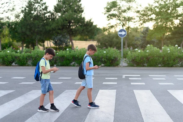 Two Children Look Mobile Phones While Crossing Crosswalk Street Concept — Stockfoto