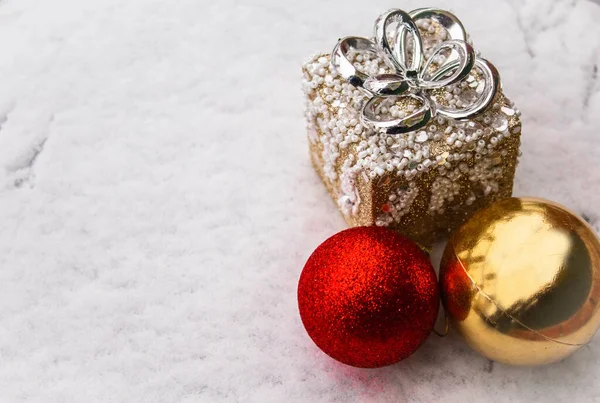 圣诞小球闪烁着红色的光芒 金光闪闪 在街上的雪地里挂着玩具礼物 近距离俯瞰着上方的美景 — 图库照片