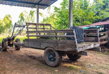 Bir çiftliğe park edilmiş ahşaptan yapılmış bir tarımsal traktör römorku.