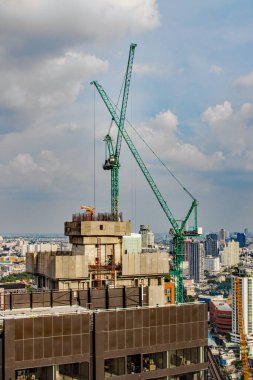 Tamamlanması gereken yüksek katlı bir projenin çatısındaki vinç inşaatı veya tırmanışı