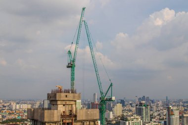 Tamamlanması gereken yüksek katlı bir projenin çatısındaki vinç inşaatı veya tırmanışı