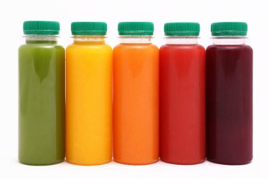 Plastik şişelerde meyve ve sebze suyu beyaz arka planda izole edilmiş, kopyalama alanı, taklit et.