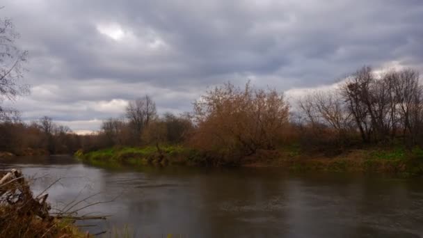 Темні хмари біжать над річкою в осінній день. Тімелапсе — стокове відео
