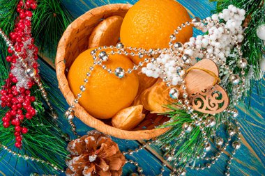 Yeni yıl havası. Noel ağacı dalları ve Noel süslemeleri olan portakallar