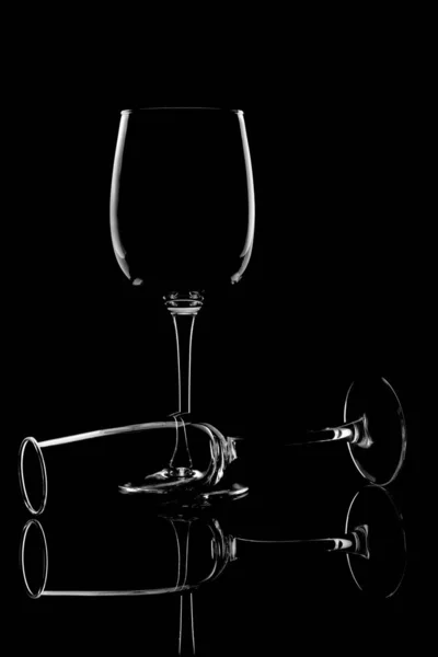 The outline of glass glasses on a black background. Form. Light — стоковое фото