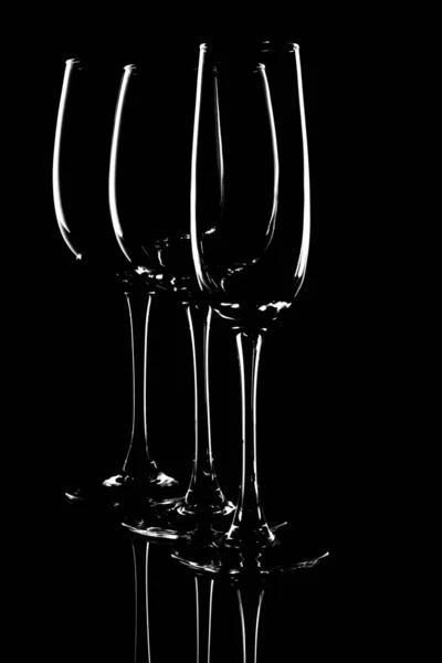 The outline of glass glasses on a black background. Form. Light — стоковое фото