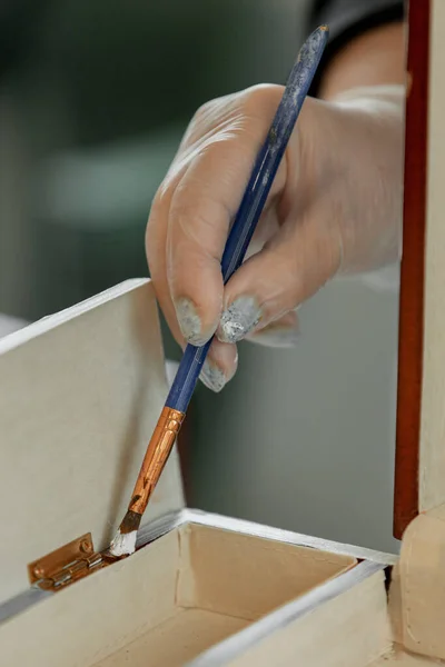 Womens gloved hands work with an artistic brush, repainting furniture — Stock Photo, Image