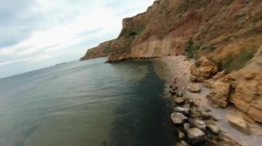 FPV bulutlu bir günde sahil uçurumunun üzerinden uçuyor.