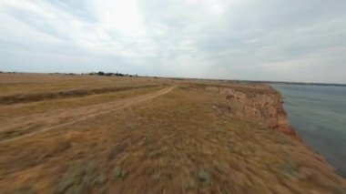FPV bulutlu bir günde sahil uçurumunun üzerinden uçuyor.