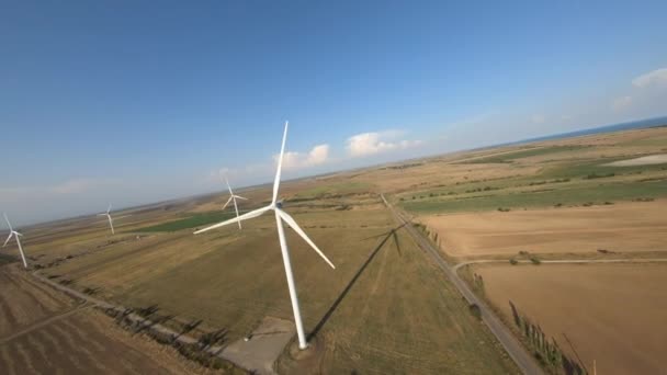FPV-vlucht tussen windmolenparken in het veld — Stockvideo