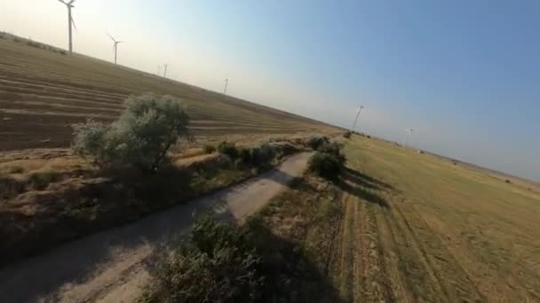 Lot FPV wśród farm wiatrowych w terenie — Wideo stockowe