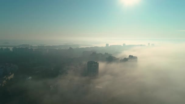 Flydroneopptak av å fly over byen i tåke ved daggry – stockvideo