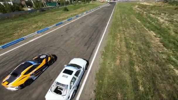 FPV İHA yarışmada iki drift arabayı kovalıyor. — Stok video