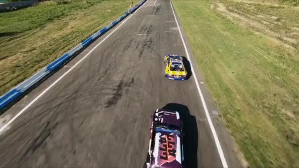 FPV İHA yarışmada iki drift arabayı kovalıyor. Yavaş çekim.. — Stok video