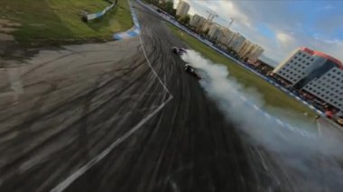 FPV İHA yarışmada iki drift arabayı kovalıyor. Yavaş çekim..