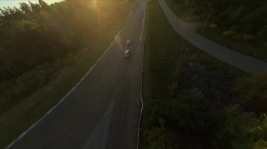 FPV İHA yarışmada iki drift arabayı kovalıyor. Yavaş çekim..