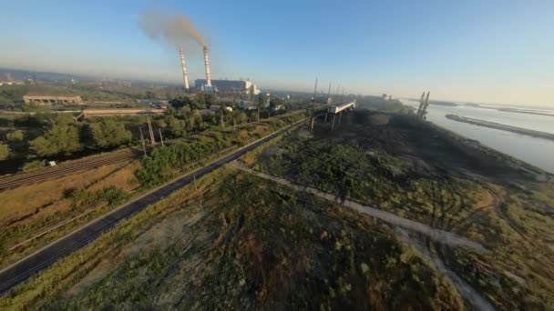 FPV Drohnenflug zum Wärmekraftwerk mit Kohle-Lieferterminal mit Hafenkränen — Stockvideo