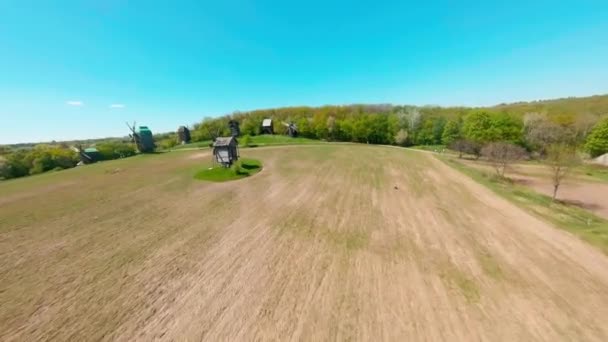FPV drone πετά πάνω από το ουκρανικό αυθεντικό χωριό Πιρογκόβο με ανεμόμυλους κοντά στο Κίεβο — Αρχείο Βίντεο