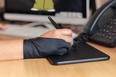 Bilgisayarlı grafik tabletli bir ressamın eli.