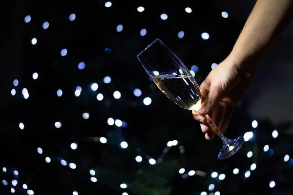 Kvinnlig Hand Håller Ett Glas Champagne Mot Bakgrund Julgran Firar — Stockfoto