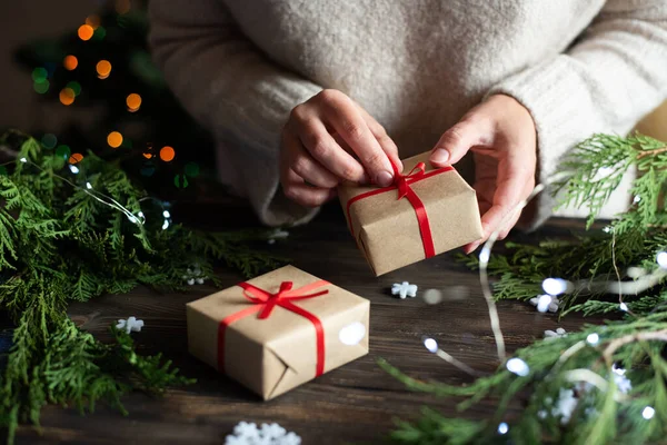 Kadın hediye paketi kağıt ve kırmızı kurdele, Noel için hediye hazırlama, tatil konsepti, yakın çekim.