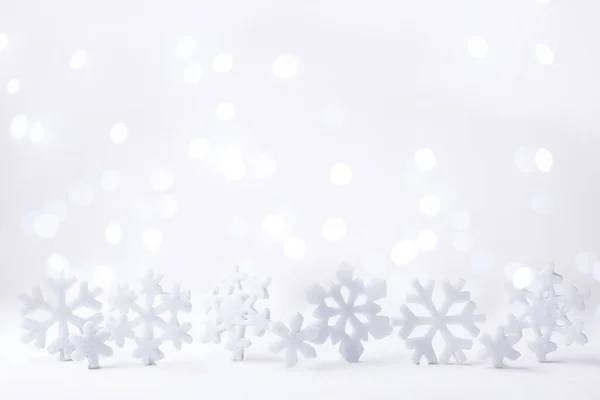 Beyaz arka planda kar taneleri ve ışıklar bokeh, Noel ve kış arkaplanı, yakın plan.