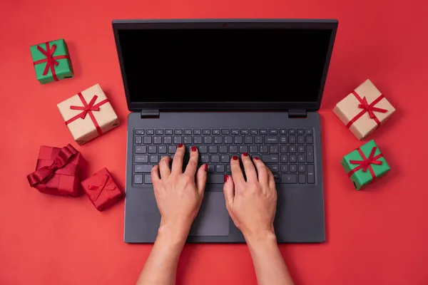Tangan Perempuan Mengetik Laptop Dengan Hadiah Berlatar Belakang Merah Bekerja — Stok Foto