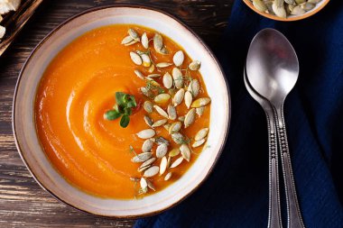 Sonbahar sebze püresi çorbası, ahşap arka planda balkabağı kremalı çorba, kırsal tarzda vejetaryen yemeği, üst manzara..