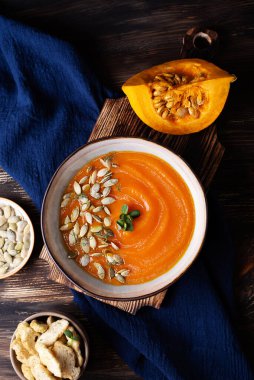 Sebze püresi çorbası, ahşap arka planda balkabağı kremalı çorba, vejetaryen sağlıklı yiyecekler, üst manzara..