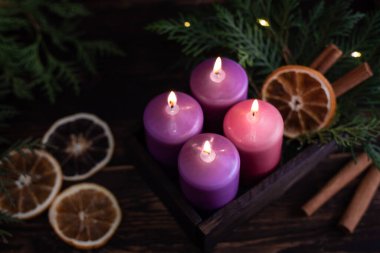 Dört mor yanan mumlu ahşap kutu. Karanlık bir arka planda, Noel arifesinde..