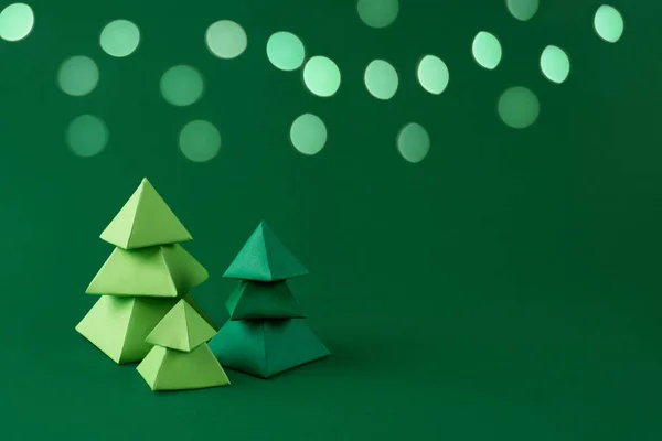 Trzy Zielone Papierowe Choinki Zielonym Tle Bokeh Światła Papierowe Rzemiosła — Zdjęcie stockowe