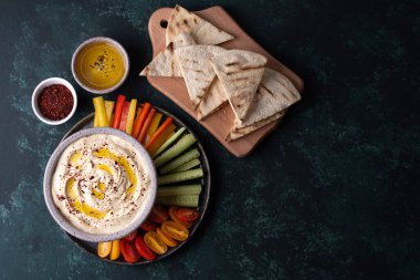 Sebzeli nohut sosu, sebzeli pide, sebzeli kase ve yeşil arka planda baharat..