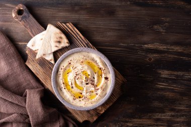 Nohut humus kasesi ve siyah ahşap masa üzerindeki pide, vegan sağlıklı beslenme, kopyalama alanı..