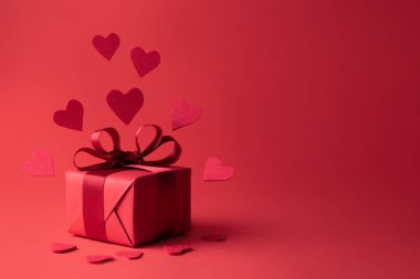 Many hearts flying from gift on red background, present for Valentine's Day and birthday.