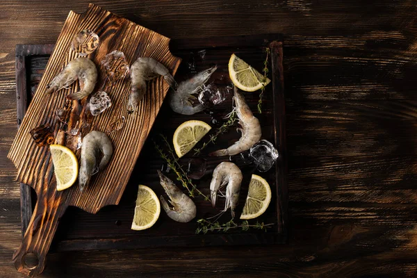 冷冻海鲜虾 柠檬片虾仁和木制底板上的冰块 — 图库照片