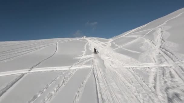 Vista aérea deportes FPV drone persecución moto de nieve corre cuesta arriba en la pendiente de invierno — Vídeos de Stock