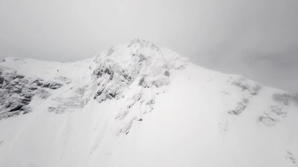 Top view sport FPV drone duik van klif naar beneden op natuurlijke winter skigebied — Stockvideo