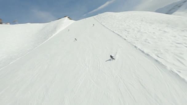 空中ビュースポーツ女性のスキーヤーの乗り物に続くFPVドローンはリゾートを彫る｜Krasnaya Polyana — ストック動画