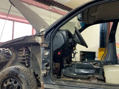 Araba tamirhanesinde paslı eski bir ceset. Araba tamiri, vücut elementlerinin restorasyonu..