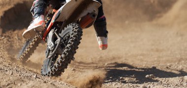 Motosikletli yarışçı çocuk motokros yarışına katılıyor, aktif ekstrem spor, toprak yolda bir motokros enkazı uçuyor.