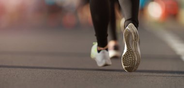 Spor ayakkabılarıyla koşan bir kadının koşu ayakkabısı.