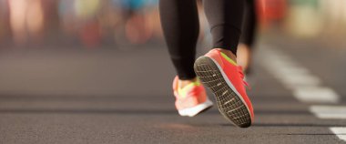 Spor ayakkabılarıyla koşan bir kadının koşu ayakkabısı.