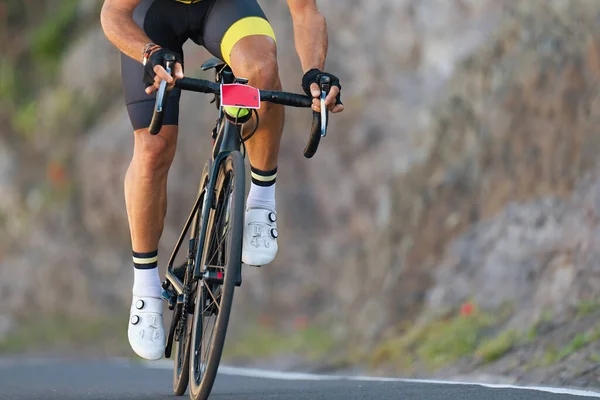 Male cyclist riding racing bicycle, man cycling on countryside summer road. Training for triathlon or cycling competition